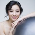 Beautiful young Chinese woman with fitness ball